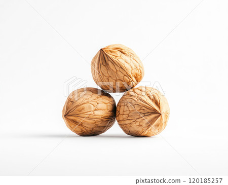 Three Whole Walnuts Stacked on White Background 120185257
