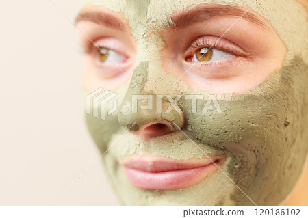Woman face with green clay mud mask 120186102