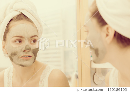 Woman face with green clay mud mask 120186103