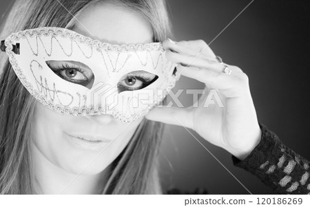 Woman holding carnival mask closeup 120186269