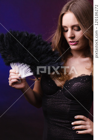 Woman holding carnival feather fan in hand. 120186272