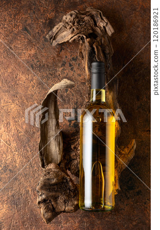 Bottle of white wine and old weathered snags on a brown vintage background. 120186921