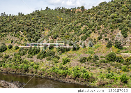A train going alongside the Barca da Amieira walkways in Amieira do Tejo, Portugal. A train going alongside the Barca da Amieira walkways in Amieira do Tejo, Portugal. 120187013