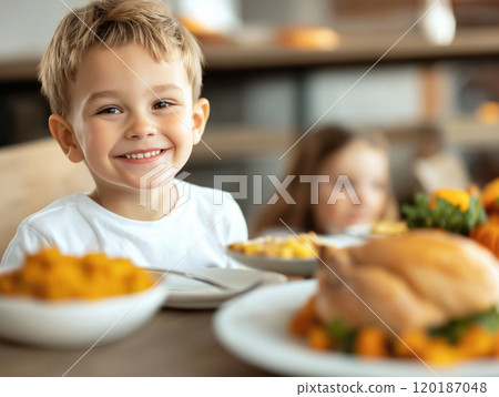 Smiling child sitting at a festive Thanksgiving table 120187048