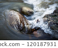 the water of the river flows around the stones 120187931