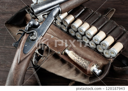 hunting double barreled side shotgun with cartridges in bandolier. hunting double barreled side shotgun with cartridges in bandolier. 120187943