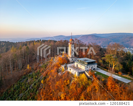 A stunning autumn sunset illuminates the Lookout Tower on Prosec Ridge. Nestled among vibrant fall foliage near Jablonec nad Nisou in the Jizera Mountains, the view is breathtaking. 120188421
