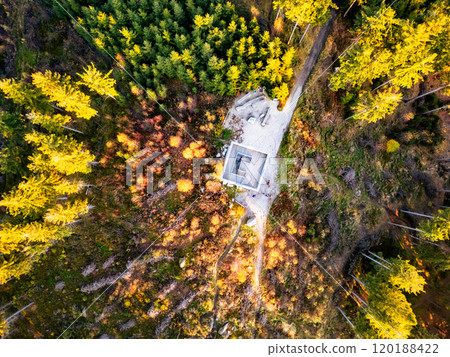 The wooden lookout tower near Liberec stands surrounded by vibrant autumn foliage as the sun sets, illuminating the landscape with warm hues of orange and gold. The wooden lookout tower near Liberec stands surrounded by vibrant autumn foliage as the sun sets, illuminating the landscape with warm hues of orange and gold. 120188422