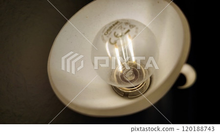 Close-up of a Vintage Light Bulb in Dim Lighting Highlighting Its Details 120188743