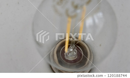 Close-up View of an Incandescent Light Bulb's Filament and Glass Structure Close-up View of an Incandescent Light Bulb's Filament and Glass Structure 120188744
