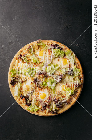 Gourmet pizza with fresh greens, eggs, and cheese on a crispy crust, unique dining experience 120189043
