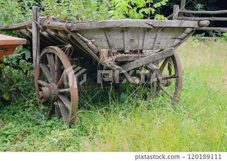 Village vehicle in nature background. Retro wooden cart. Wooden wheels. Village vehicle in nature background. Retro wooden cart. Wooden wheels. 120189111