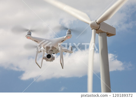 Unmanned Aircraft System (UAV) Quadcopter Drone In The Air Surveying Wind Turbines. 120189372