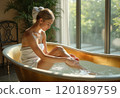 A serene woman sits gracefully in a golden bathtub, gently washing her feet in the water. The soft natural light streaming through the large windows enhances the tranquil atmosphere, surrounded by 120189759