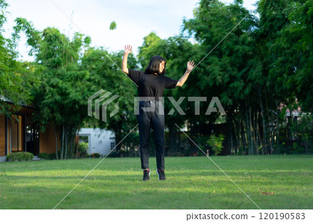 Asian short hair Woman is Joyful Jumping on the grass field garden. 120190583
