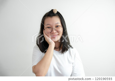 Asian Glassese Woman is touching her cheek and thinking somethings on white background in studio light. Asian Glassese Woman is touching her cheek and thinking somethings on white background in studio light. 120190593