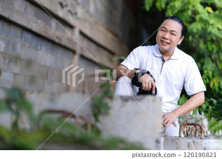 Asian Professional cameraman sits and thinks about how to create a creativity photo in the construction area background and environment. 120190821