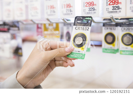Woman buying button batteries at the supermarket 120192151