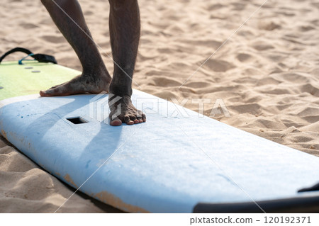 An example position of Asian professional feet on a surfboard in surfing board lesson study and training by the teacher. 120192371