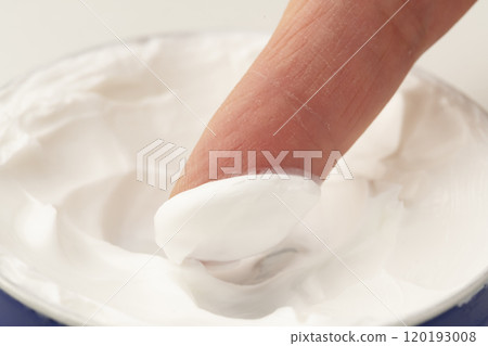 Close-up of hands applying hand cream 120193008