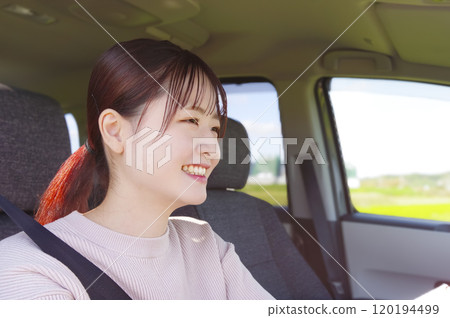 Smiling young woman driving Smiling young woman driving 120194499