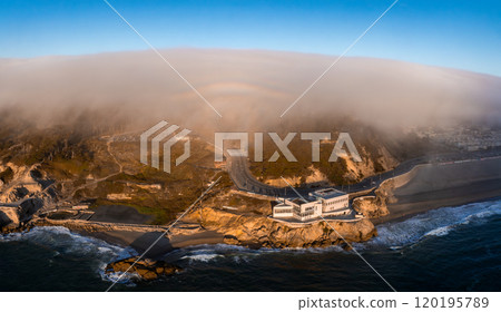 The iconic Cliff House stands on a rocky outcrop in San Francisco, California, overlooking the Pacific Ocean with fog covered hills in the background. The iconic Cliff House stands on a rocky outcrop in San Francisco, California, overlooking the Pacific Ocean with fog covered hills in the background. 120195789