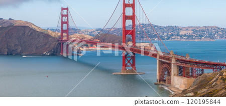 The Golden Gate Bridge's International Orange color contrasts with blue waters and Marin County hills, capturing its iconic structure on a clear day. The Golden Gate Bridge's International Orange color contrasts with blue waters and Marin County hills, capturing its iconic structure on a clear day. 120195844