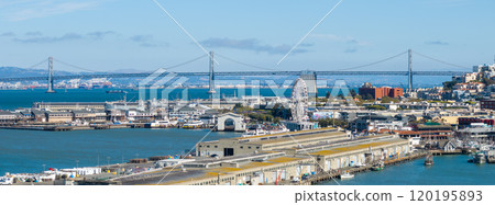 Aerial view of San Francisco featuring the Bay Bridge, bustling waterfront, and Pier 39 with a Ferris wheel. Blue bay waters contrast with city architecture. Aerial view of San Francisco featuring the Bay Bridge, bustling waterfront, and Pier 39 with a Ferris wheel. Blue bay waters contrast with city architecture. 120195893