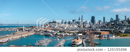 Panoramic aerial view of San Francisco featuring Transamerica Pyramid, Salesforce Tower, Coit Tower, and Bay Bridge with boats along the waterfront. 120195896