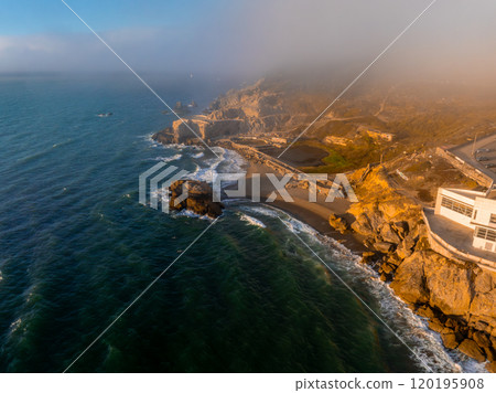 Aerial view of San Francisco's rugged coastline, featuring Cliff House, Sutro Baths remnants, and Pacific Ocean waves under a foggy sky. Aerial view of San Francisco's rugged coastline, featuring Cliff House, Sutro Baths remnants, and Pacific Ocean waves under a foggy sky. 120195908
