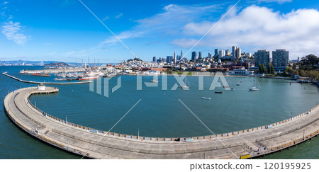 Panoramic view of San Francisco's skyline featuring the Transamerica Pyramid, a curved pier, and boats in the bay under a clear blue sky. 120195925