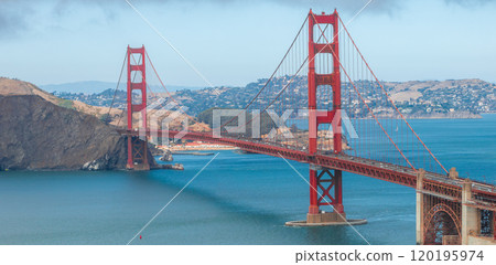 The Golden Gate Bridge's International Orange color contrasts with blue waters and Marin County hills, capturing its iconic structure in clear detail. 120195974