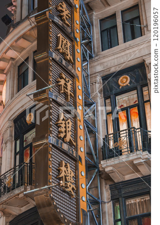 A historic building in Shanghai features ornate architecture with intricate details. A prominent vertical sign with Chinese characters is illuminated. 120196057