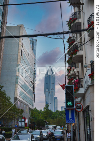 Shanghai street scene with Tomorrow Square in the background, modern buildings, red flower adorned balconies, and a bike friendly traffic light. Shanghai street scene with Tomorrow Square in the background, modern buildings, red flower adorned balconies, and a bike friendly traffic light. 120196373