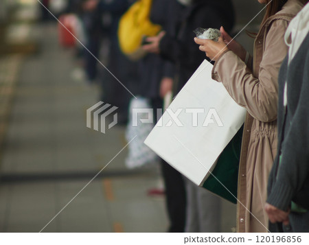 A woman waiting for a train on the platform during the morning commute A woman waiting for a train on the platform during the morning commute 120196856