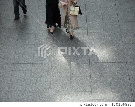 A beautiful middle-aged woman walking in a busy street in winter, photographed from a high angle 120196885