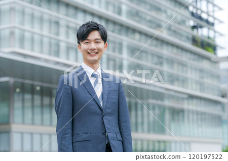 年輕商人在辦公大樓前微笑 年輕商人在辦公大樓前微笑 120197522