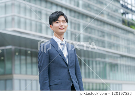 年輕商人在辦公大樓前微笑 年輕商人在辦公大樓前微笑 120197523
