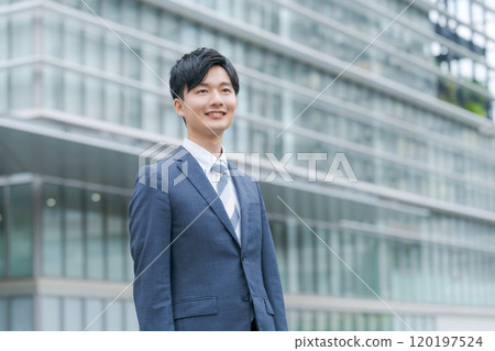 年輕商人在辦公大樓前微笑 年輕商人在辦公大樓前微笑 120197524