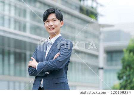 Businessman with arms folded in front of a building 120199224