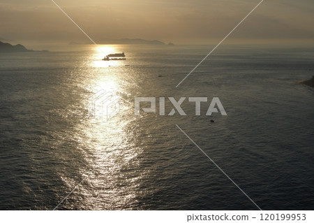 海面和一艘大船的輪廓被耀眼的夕陽照亮 120199953