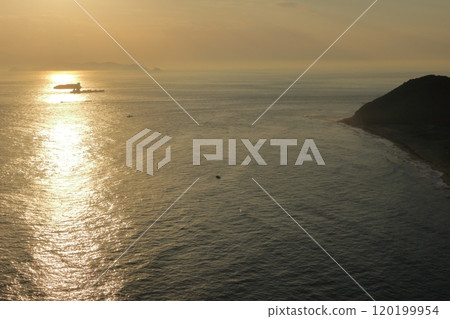 海面和一艘大船的輪廓被耀眼的夕陽照亮 120199954