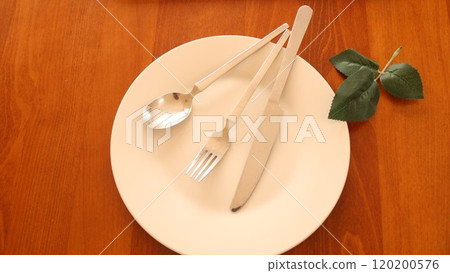 由在一張木桌安置的綠色盤和利器的膳食結束的信號 120200576