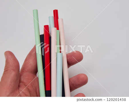 Red and blue pencils for marking held in one hand and various other colorful pencils Red and blue pencils for marking held in one hand and various other colorful pencils 120201438