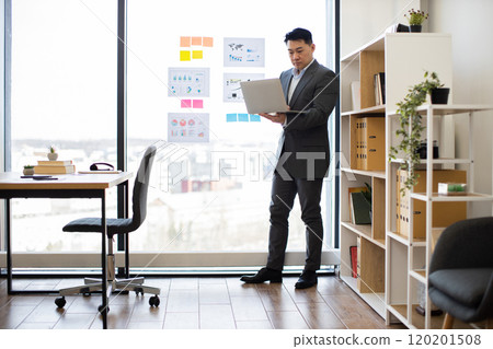 Asian businessman analyzing data during video call in modern office 120201508