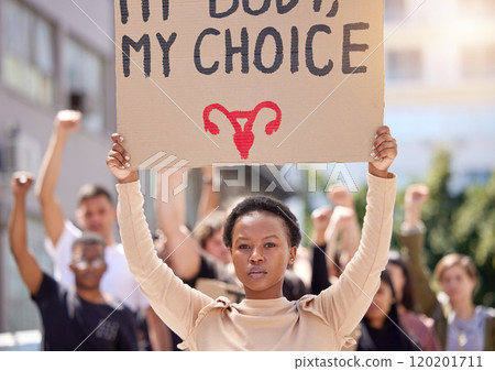 Youll never take whats mine. Shot of a young woman at a rally holding a placard. Youll never take whats mine. Shot of a young woman at a rally holding a placard. 120201711