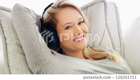My fun time at home, just chilling listening to music. Shot of an attractive young woman listening to music with headphones at home. 120201721