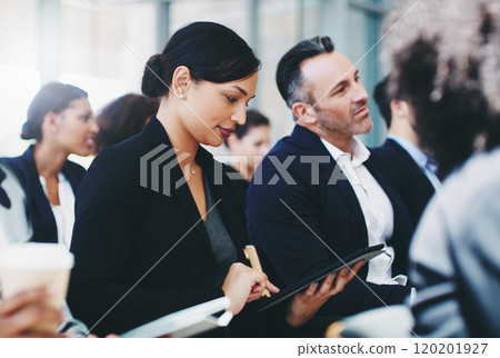 Taking as much info as she can from this presentation. Shot of a young businesswoman using a digital tablet while attending a conference. 120201927