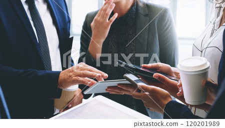 Technology helps our business move faster. Cropped shot of an unrecognizable group of businesspeople standing and using technology while in the office. 120201989