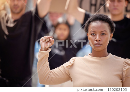 Dedicated to the cause. Shot of a young woman with her fist raised in solidarity at a march. Dedicated to the cause. Shot of a young woman with her fist raised in solidarity at a march. 120202103